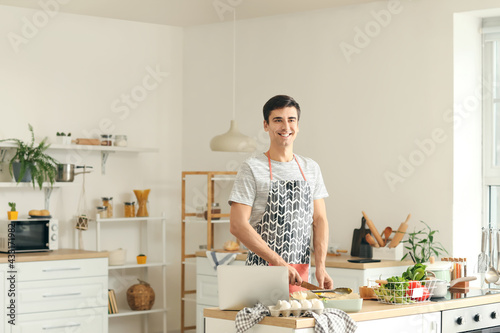 Young man cooking in kitchen