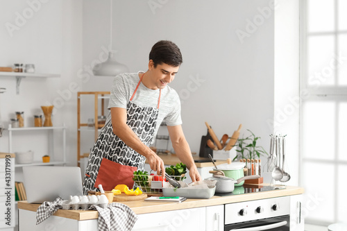 Young man cooking in kitchen