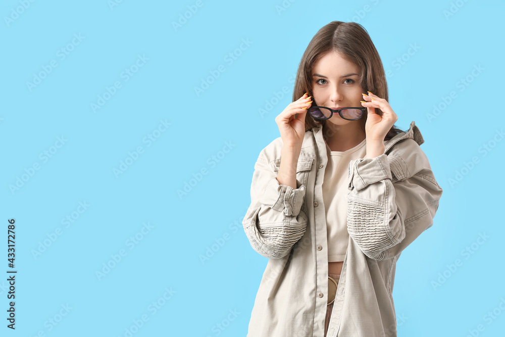 Young woman wearing eyeglasses on color background Young woman wearing eyeglasses on color background