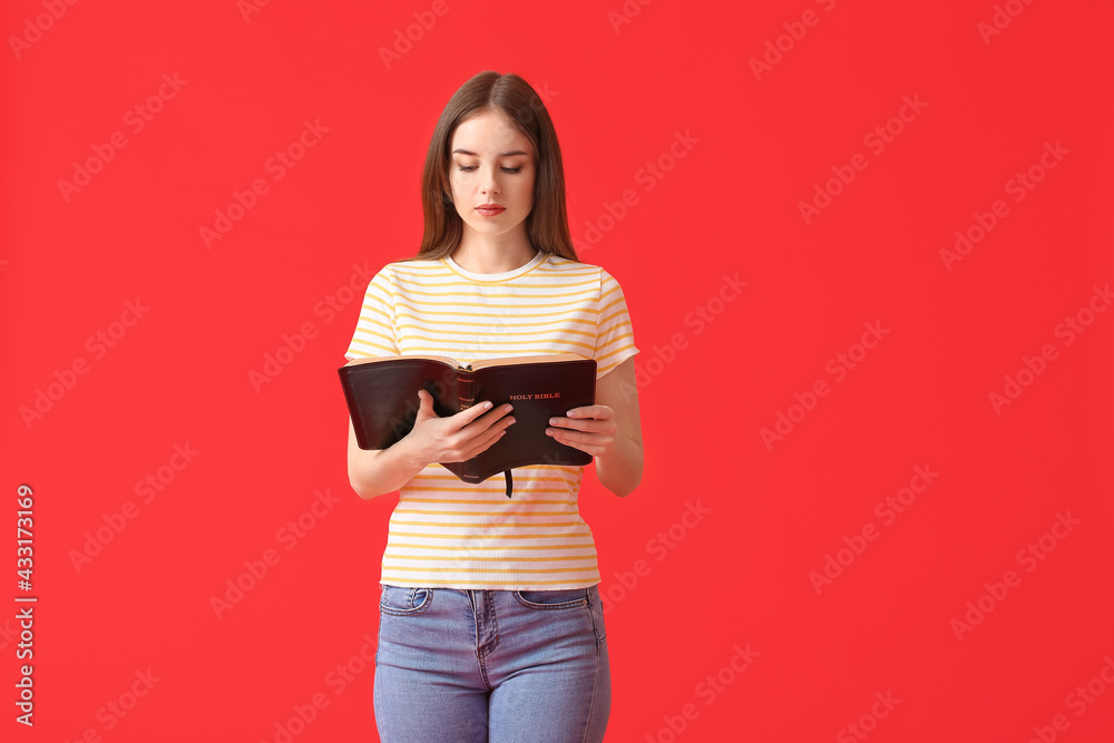 Young woman with Bible on color background Young woman with Bible on color background