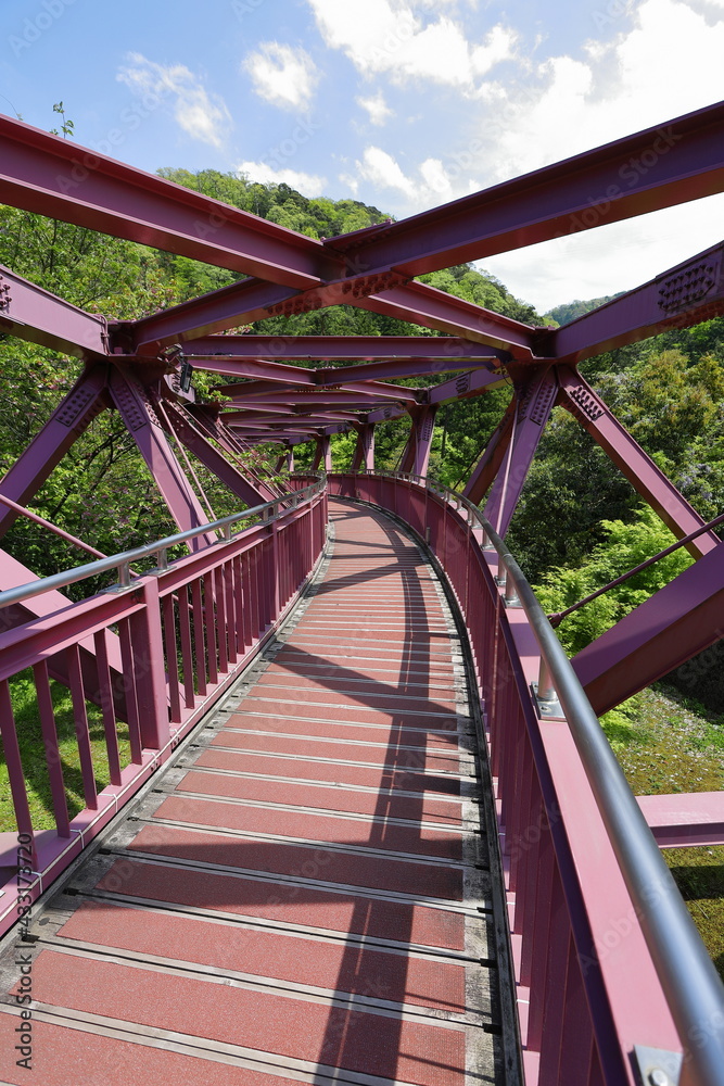 山奥にある湾曲した赤い鉄橋の風景