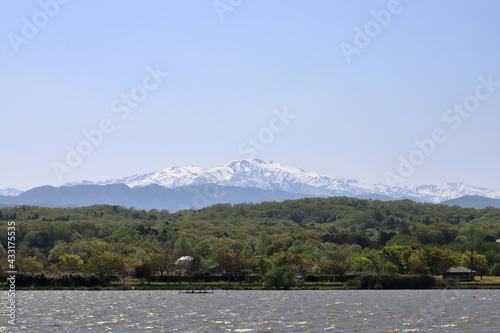湖畔から雪が積もる山が見える風景