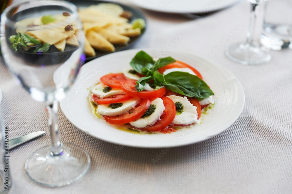 plate of slices of mozzarella cheese and tomatoes on a served table