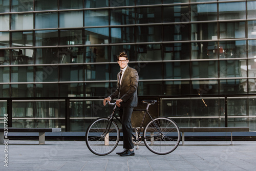 Fototapeta Naklejka Na Ścianę i Meble -  Handsome young business man with his modern bicycle.
