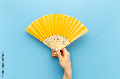 Hand fan made of bamboo and paper in female hand photo