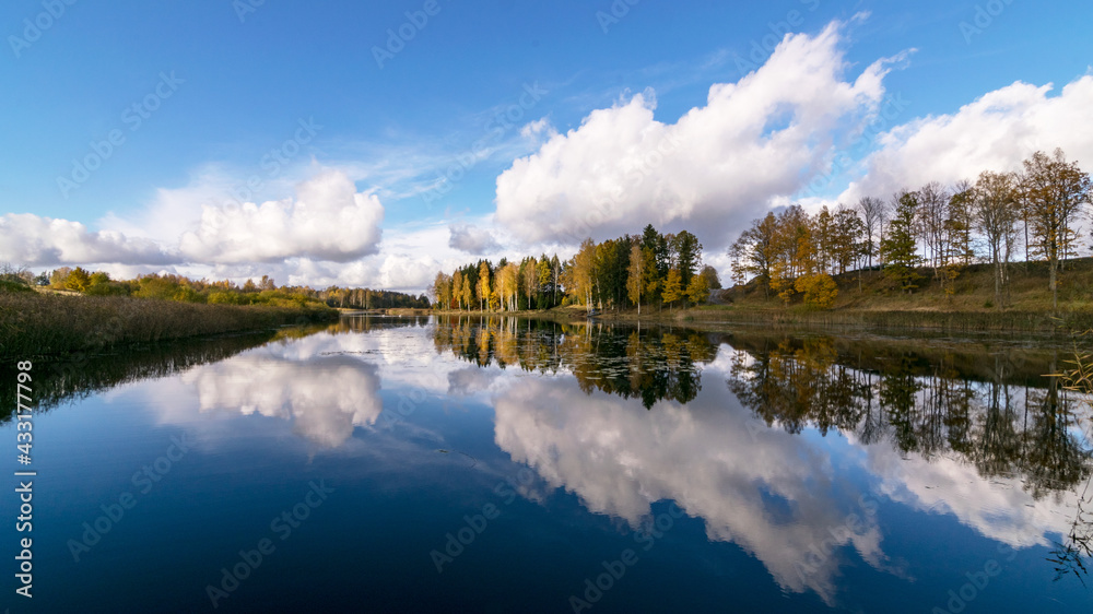 colorful autumn panoramas with yellow trees by the lake, beautiful and colorful reflections in the calm lake water, golden autumn