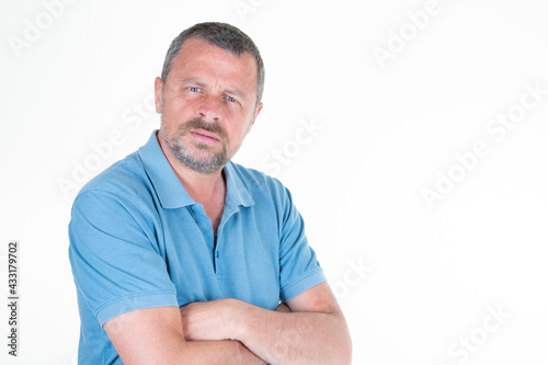 handsome mature man arms crossed on white background aside copy space in blue shirt © OceanProd