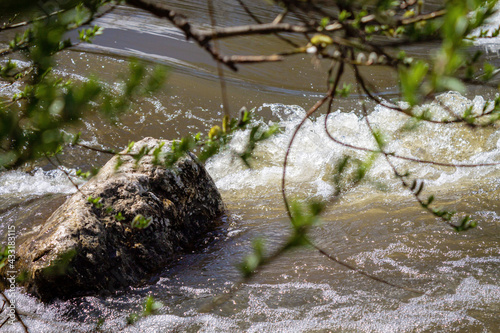 Strong river current, splash of water, waves and large stones. photo