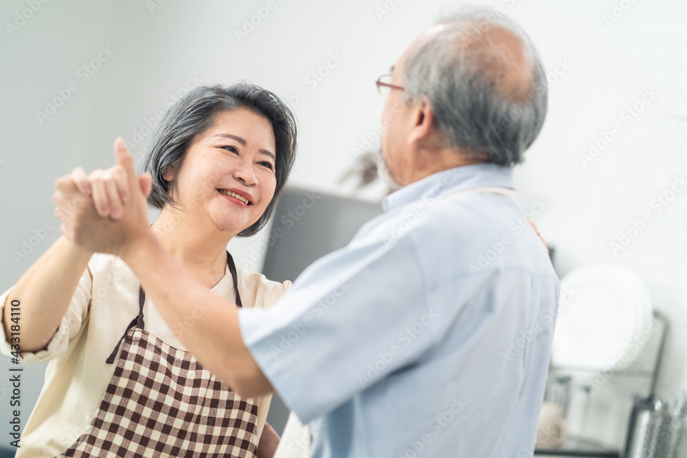 Asian senior couple dancing in the kitchen, Enjoy retirement life.