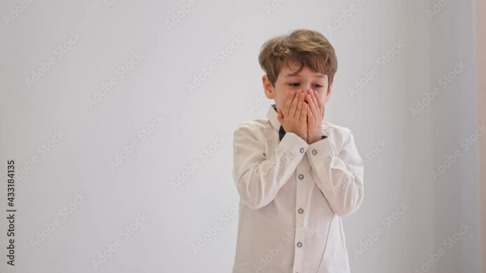 Close up portrait of little shocked boy touching his face. childhood, expressions and people concept Close up portrait of little shocked boy touching his face. childhood, expressions and people concept