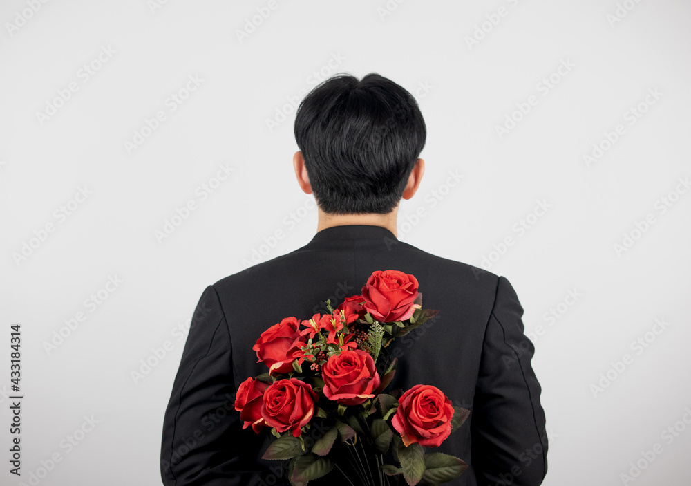 Rear view of man hiding bouquet of roses isolated on white. Rear view of man hiding bouquet of roses isolated on white.