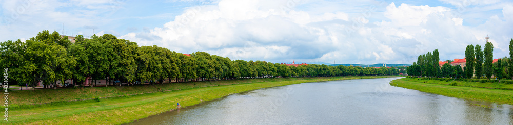 panorama of river uzh between linden and chestnut alleys on the nezalezhnosti and kyiv embankments. popular travel destination. beautiful urban scenery on a sunny day
