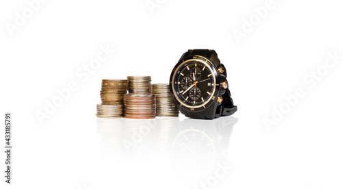 wrist watch and towers of coins on a white background