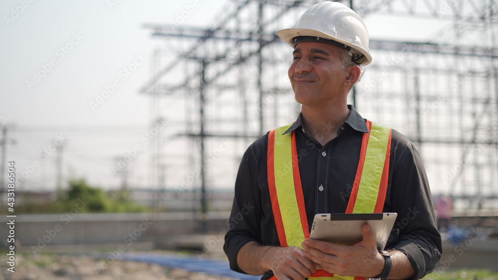 senior construction worker or architect using digital tablet checking structure in construction site outdoors Hand shading with Hot weather and sunny. builders in hard hat inspecting and working senior construction worker or architect using digital tablet checking structure in construction site outdoors Hand shading with Hot weather and sunny. builders in hard hat inspecting and working