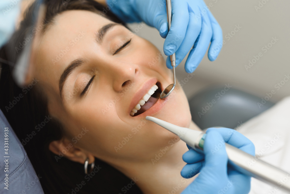 Female dentist examines the smile of a young woman after treatment, teeth brushing or enamel whitening. First person close-up shooting Female dentist examines the smile of a young woman after treatment, teeth brushing or enamel whitening. First person close-up shooting