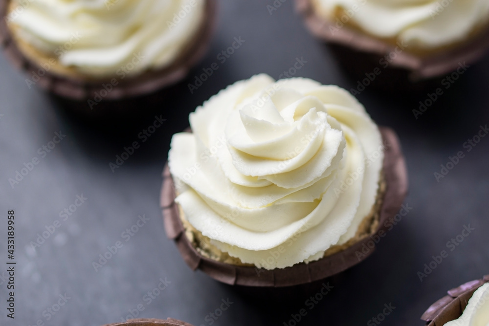 Top view cupcakes with white butter cream on dark background. Top view cupcakes with white butter cream on dark background.