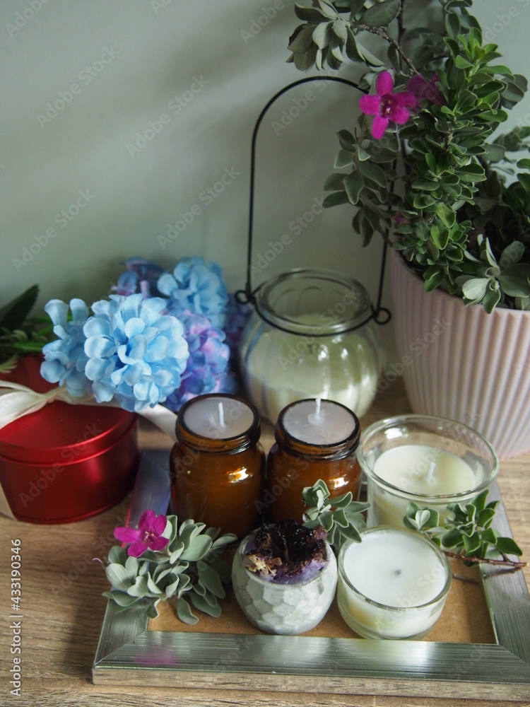 Candles and flowers are placed on a wooden table with decorations, giving a feeling of warmth and wanting to be at home. Candles and flowers are placed on a wooden table with decorations, giving a feeling of warmth and wanting to be at home.