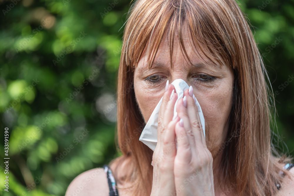 Mature woman blowing her nose Mature woman blowing her nose