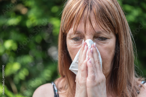 Mature woman blowing her nose