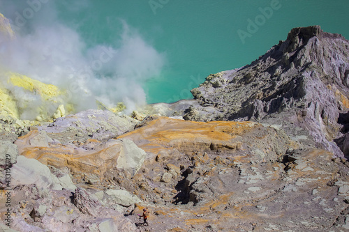 Blue waters of Kawah Ijen acid lake and sulfur mines from the top of volcano. The Ijen volcano complex is a group of composite volcanoes in the Banyuwangi Regency of East Java island, Indonesia.