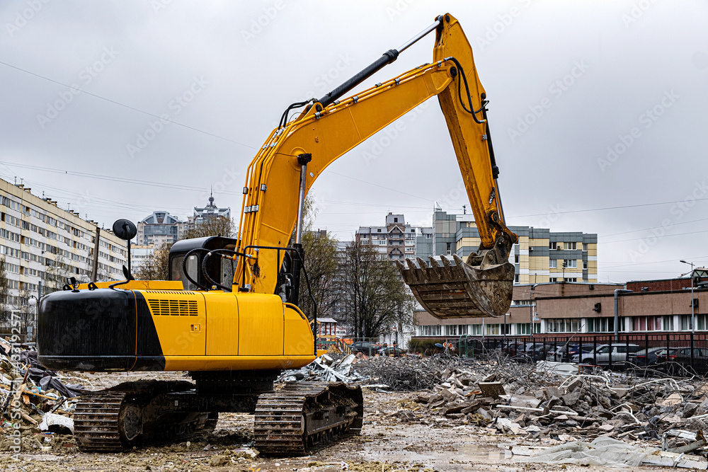 An excavator among a pile of garbage after dismantling an illegally constructed building. An excavator among a pile of garbage after dismantling an illegally constructed building.