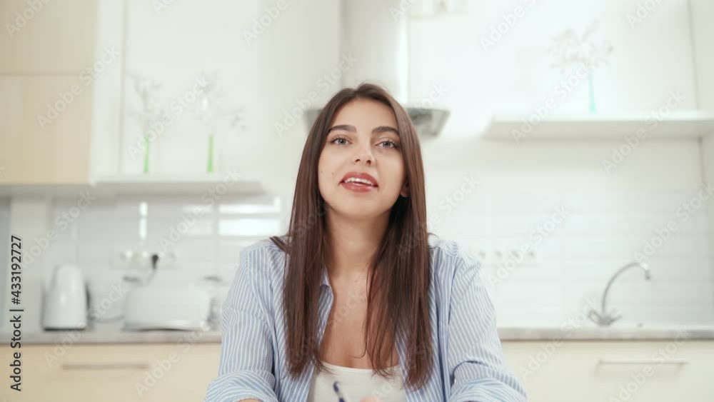 Close up portrait of smiling attractive brunette woman student telling information to the camera online at home. Concept of process communication online and working or studying during quarantine. Close up portrait of smiling attractive brunette woman student telling information to the camera online at home. Concept of process communication online and working or studying during quarantine.