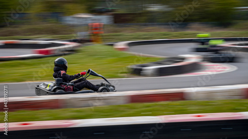 A panning shot of a racing kart as it circuits a track.