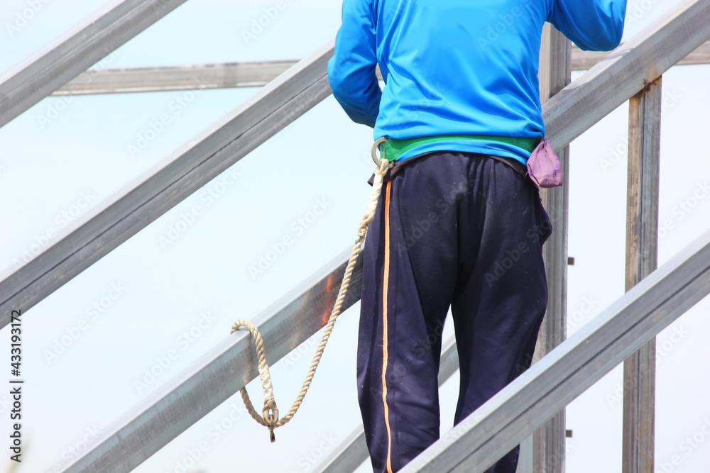 construction worker working on roof structure using rope belt safety him self, safety concept