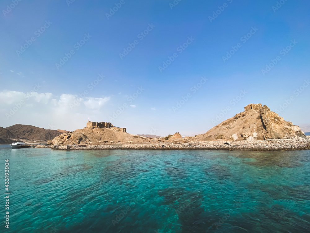 Mobile photo of Pharaoh island, Egypt. Seascape with ancient Castle of Saladin on the Farun Island in the Gulf of Aqaba. Old fortress of Sultan Salah El Din in Taba, travel on Sinai Peninsula.