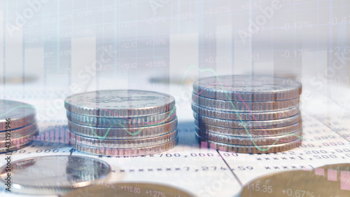 Growing money saving and investment concept; double exposure of coins stack on bank account book with growing trend candle stick graph.