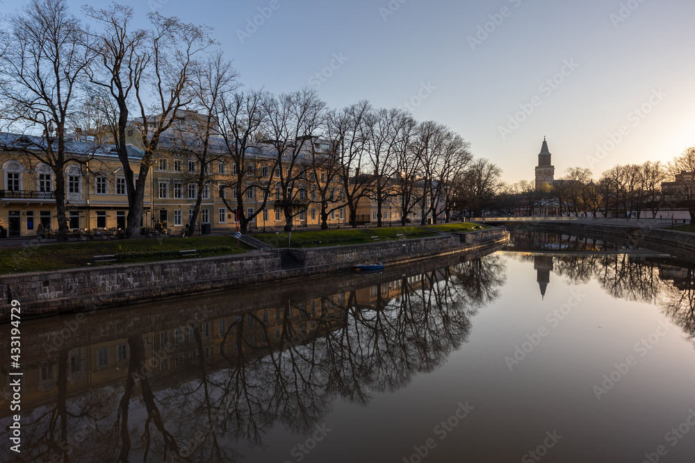 Scenic view of calm Aura river at sunrise with the Cathedral in the background in Turku, Finland.