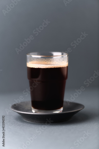 Coffee in glass cup on gray background. Close up. 
