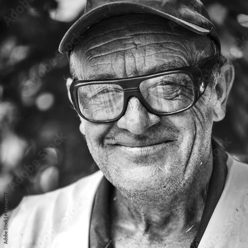 Portrait of smiling old man with wrinkled face. Black and white portrait .