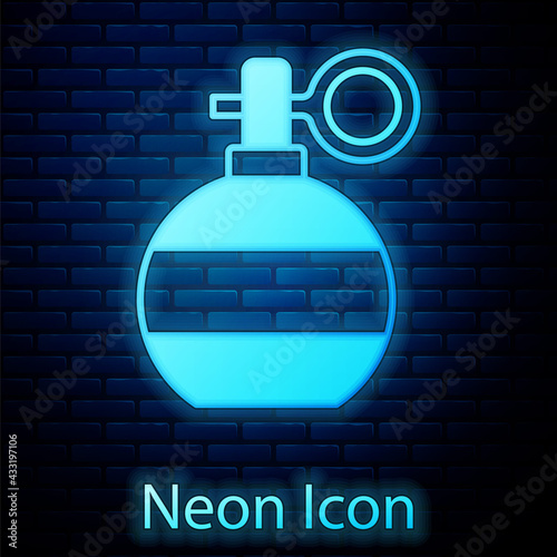 Glowing neon Hand grenade icon isolated on brick wall background. Bomb explosion. Vector