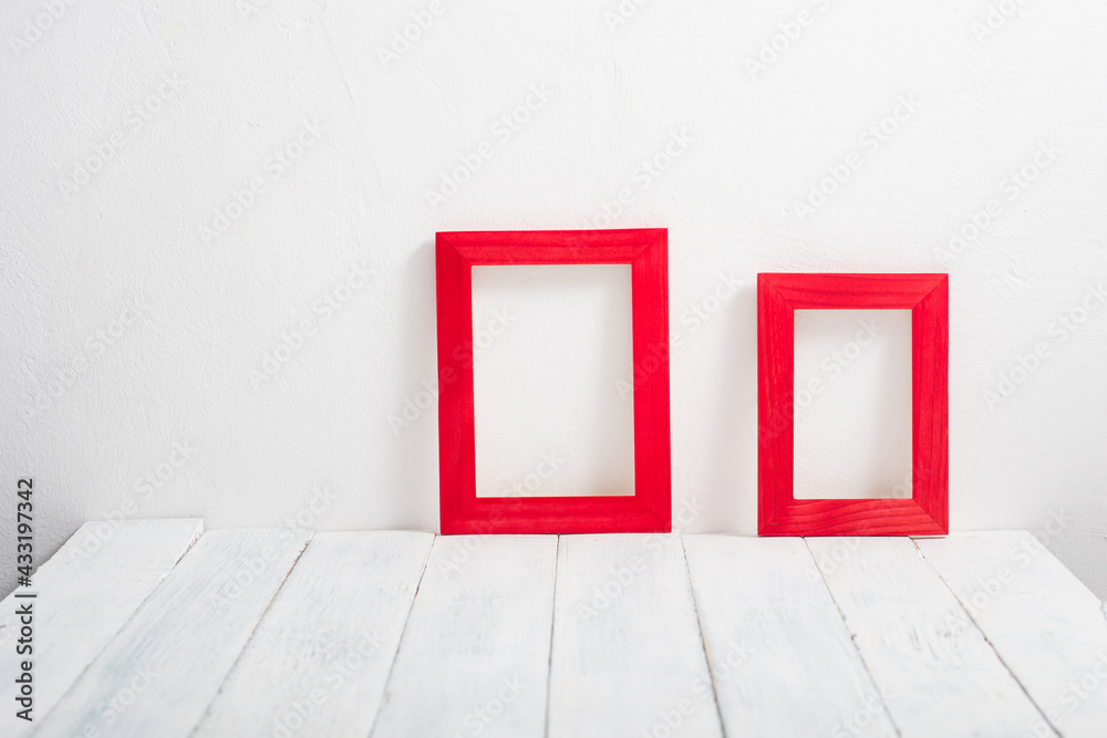 pair of empty red picture frames on white wooden table pair of empty red picture frames on white wooden table