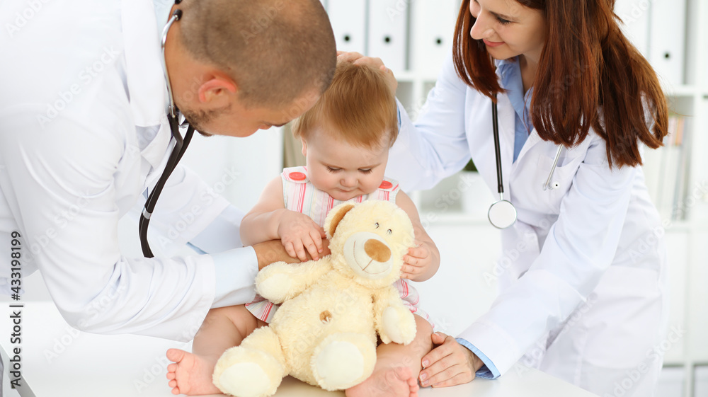 Happy smiling girl-child at usual medical inspection. Doctor and female toddler patient in the clinic. Medicine, healthcare concepts Happy smiling girl-child at usual medical inspection. Doctor and female toddler patient in the clinic. Medicine, healthcare concepts