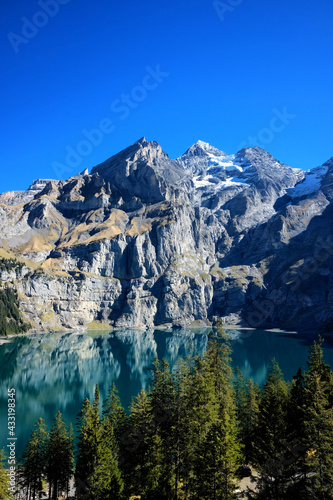 Oeschinensee lake in Kandersteg, Switzerland. Panoramic view of the mountains and azure water on a clear sunny summer day. Popular tourist attraction. © art4stock