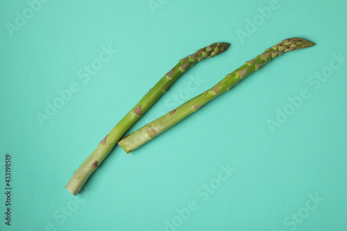 Fresh green asparagus on mint background, space for text