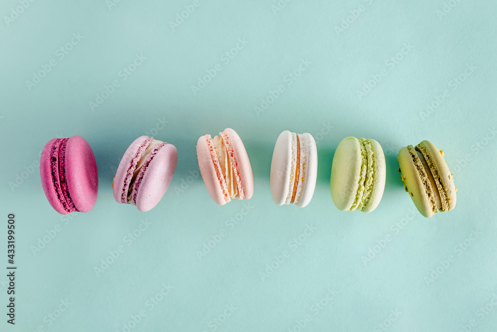 Colorful dessert macarons on pastel green background Colorful dessert macarons on pastel green background