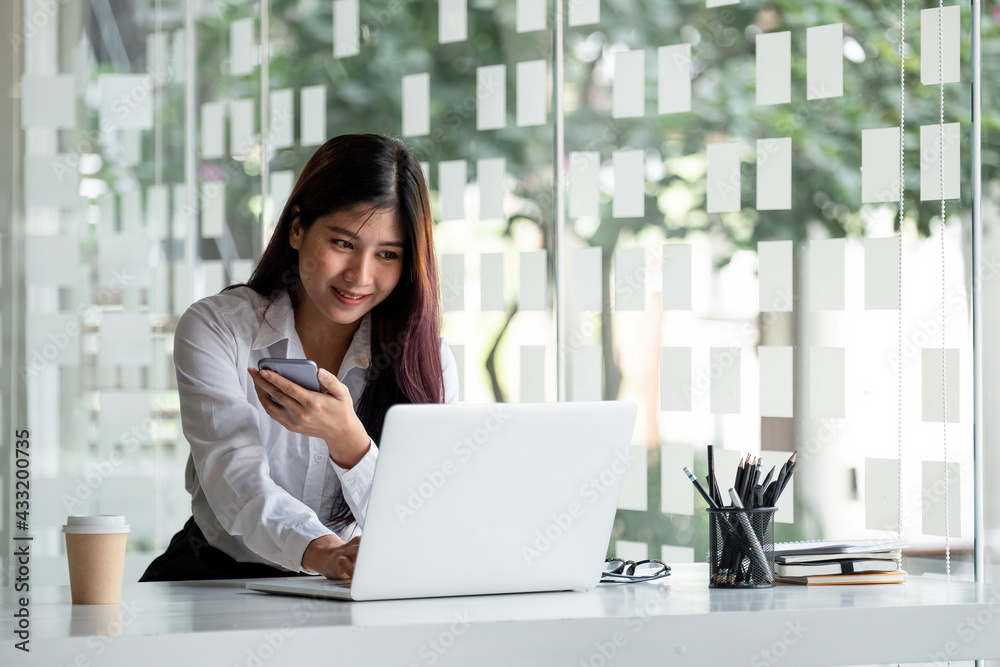 Woman using laptop computer and smartphone for online education at home Woman using laptop computer and smartphone for online education at home