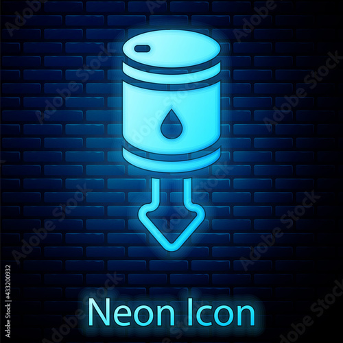 Glowing neon Drop in crude oil price icon isolated on brick wall background. Oil industry crisis concept. Vector