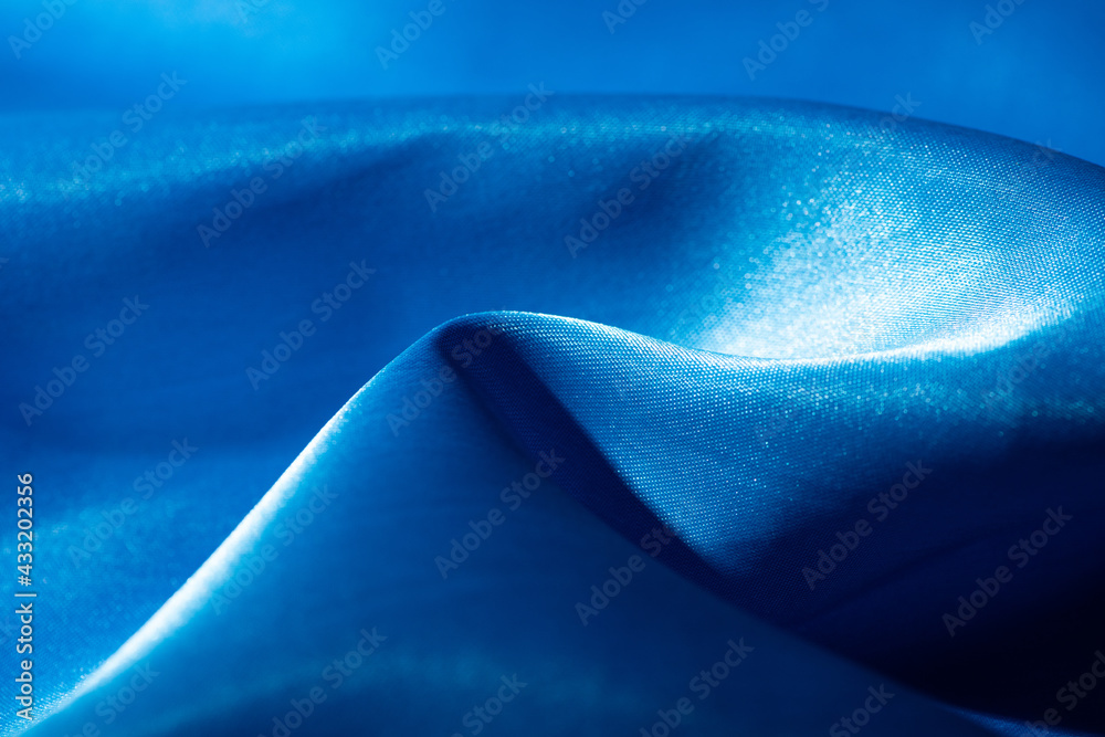 Abstract blue silk fabric texture background. Cloth soft wave. Creases of satin Abstract blue silk fabric texture background. Cloth soft wave. Creases of satin