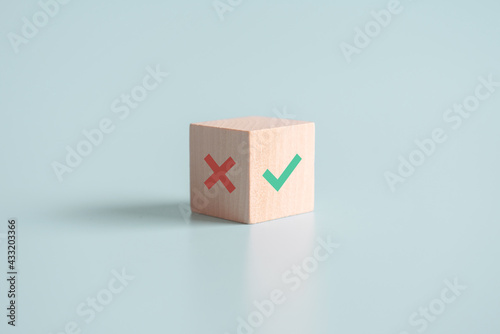 True and false symbols accept rejected for evaluation, Yes or No on wood blogs on blue background. photo