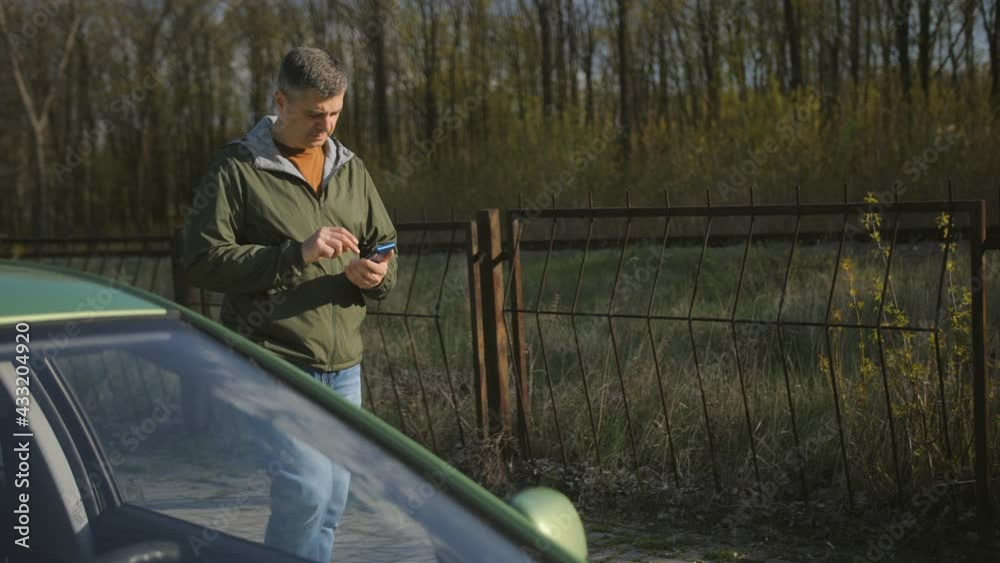 Man unlocks car door with phone app. Car sharing, transport. Man unlocks car door with phone app. Car sharing, transport.