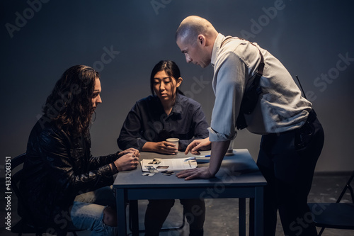 Canvas Print A police investigator with a gun in a holster meets with a man suspected of thef