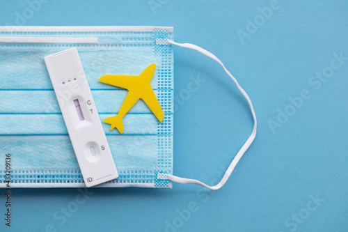 Covid travel concept. Airplane with covid19 test kit on a face mask photo