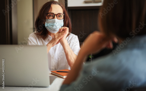 mature woman psychologist is consulting a patient at her office. Back shot of a patient talking about her mental problems during a psychologist's therapist appointment.
