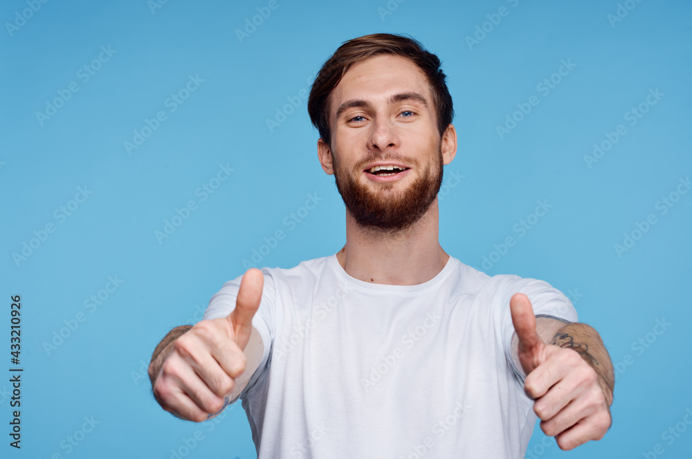 Cheerful man in a white t-shirt gesturing with his hands fashion modern style Cheerful man in a white t-shirt gesturing with his hands fashion modern style