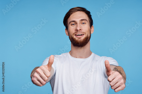 Cheerful man in a white t-shirt gesturing with his hands fashion modern style