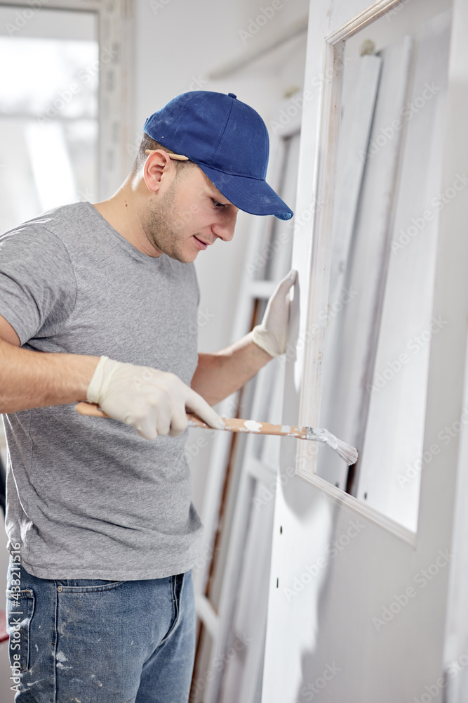 Young adult man working on a DIY budget renovation of his new home apartment. Young adult man working on a DIY budget renovation of his new home apartment.